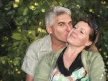 Парный портрет маслом - мужчина и женщина средних лет на фоне из зеленых листьев, мужчина седой с серыми глазами, женщина с солнцезащитными очками на голове, автор Александра